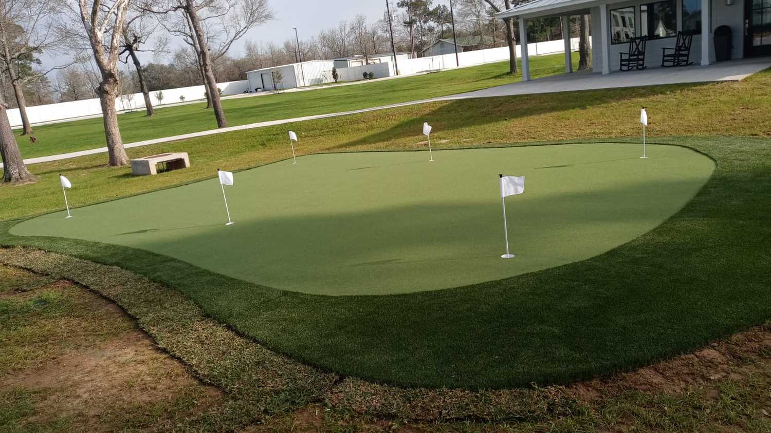 Large synthetic grass butting green installed by the expert landscape crew of Helms Landscape of Houston, Texas. artificial grass landscaping work done in Houston, Texas residence